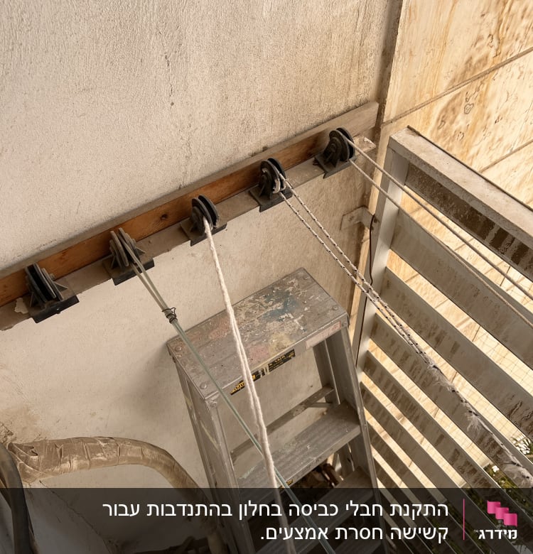 סולם מתכת, גלגלות וחבלים על קיר